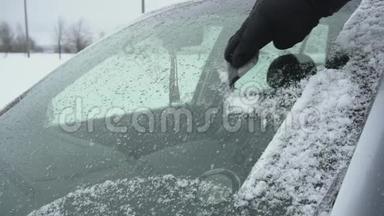 用刮刀在冬天把汽车的挡风玻璃或挡风玻璃从冰雪中清理出来。 带<strong>抓痕</strong>或擦洗器的手臂